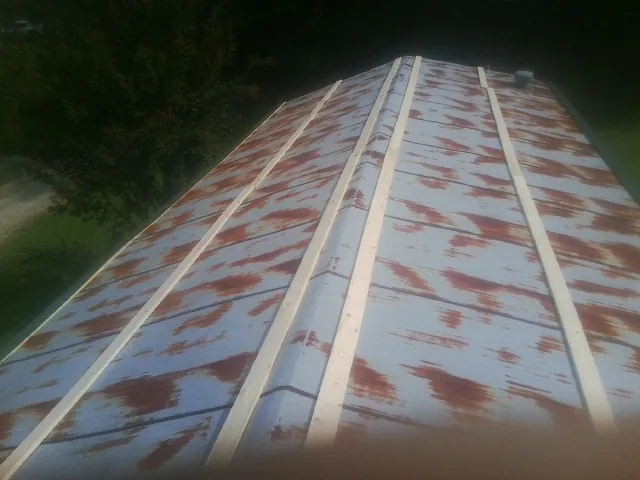 Rusted metal roof panels with new wood purlins before replacement — Storm Damage Roof Repair in Sweet Valley by Roofing Brothers