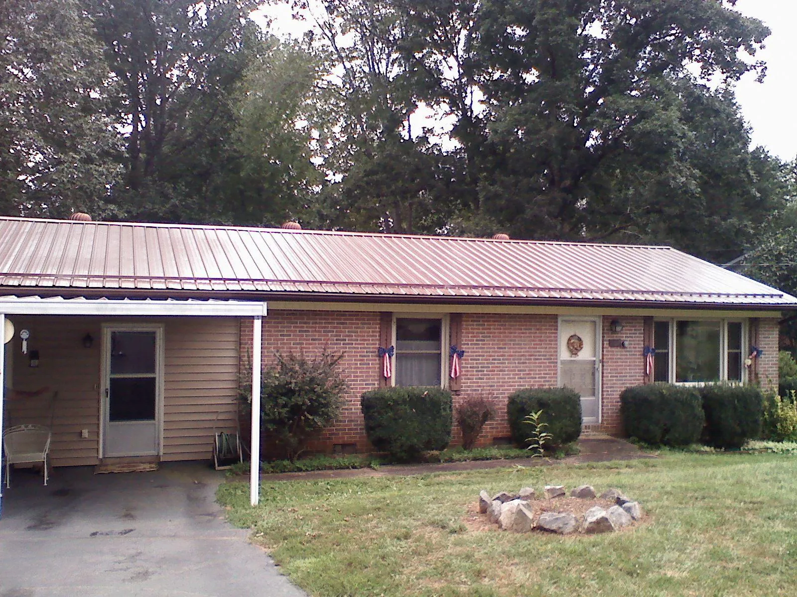 Bronze metal roof and carport on a brick ranch home — Roof Repair work by our crew in Sweet Valley